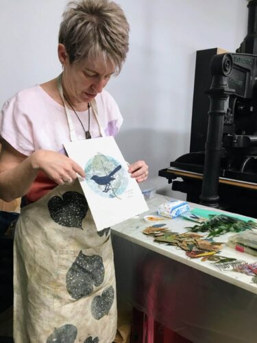 Sandra Pearce artist showing a monoprint to a workshop group